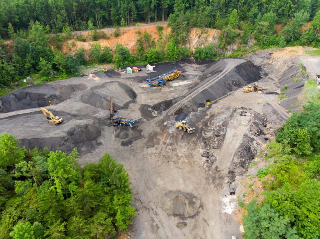 Large piles of pavement with construction trucks, owned and operated by Gray & Son a leading site and development contractor in Maryland.