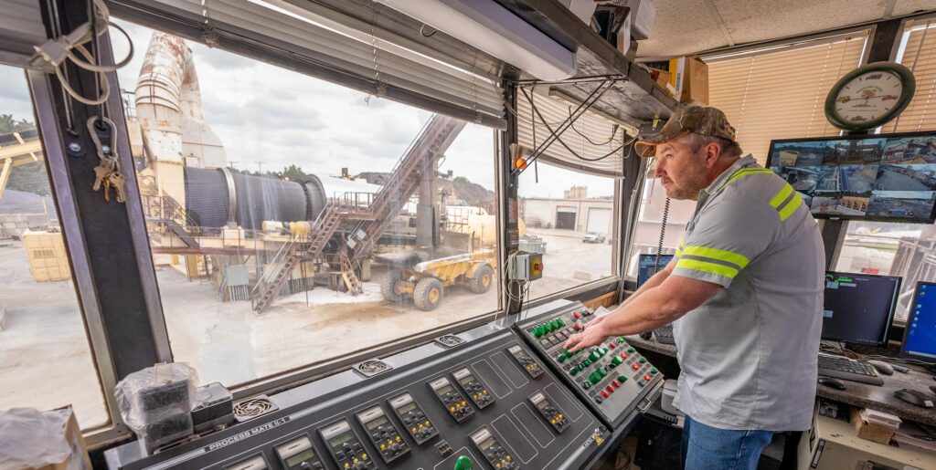 A male worker who is in a control room at an asphalt plant in Maryland owned and operated by Gray & Son a leading site and development contractor in Maryland.