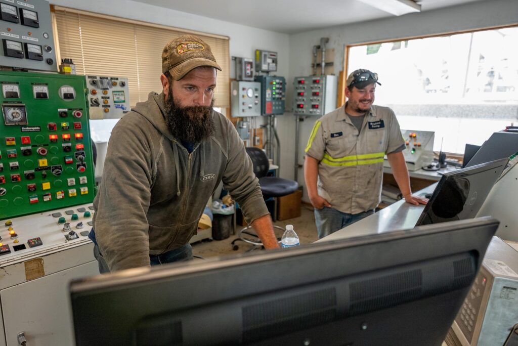 two men looking at computers in the control room at an asphalt storage site located in maryland, owned and operated by Gray & Son a leading site and development contractor in Maryland.