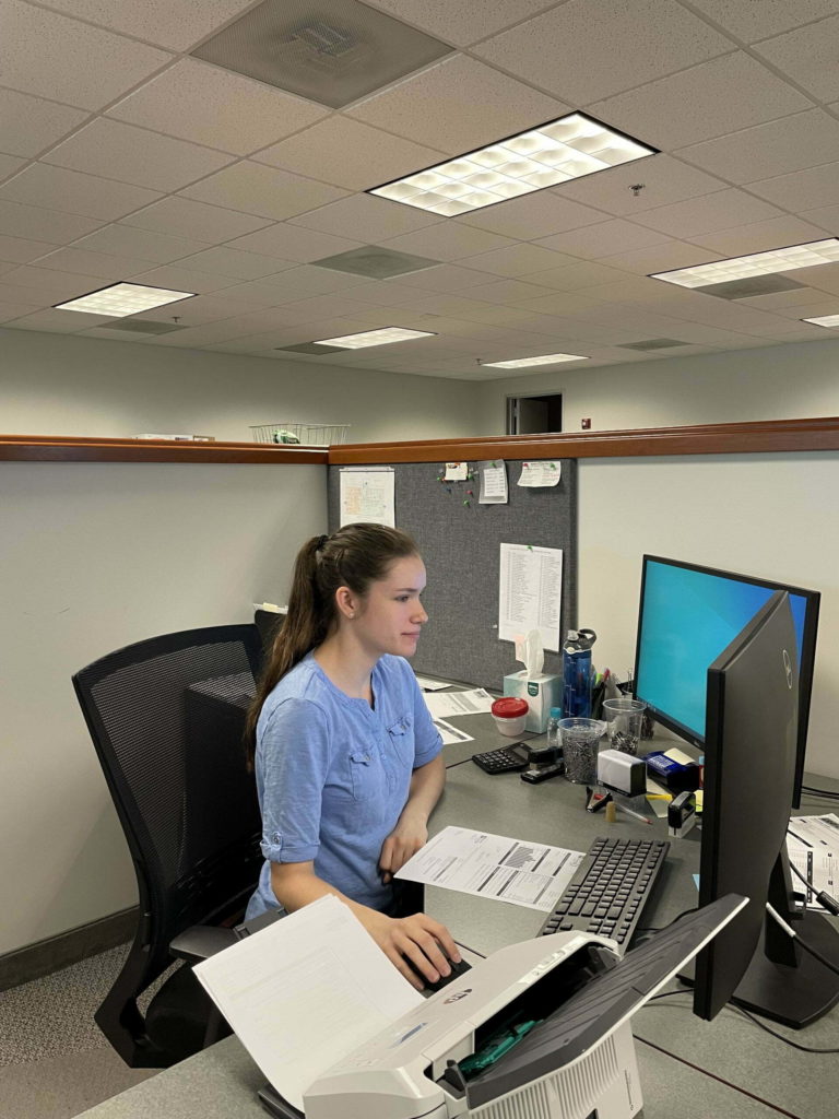 A female intern working at her computer desk working for a company named Gray & Son a leading site and development contractor in Maryland.