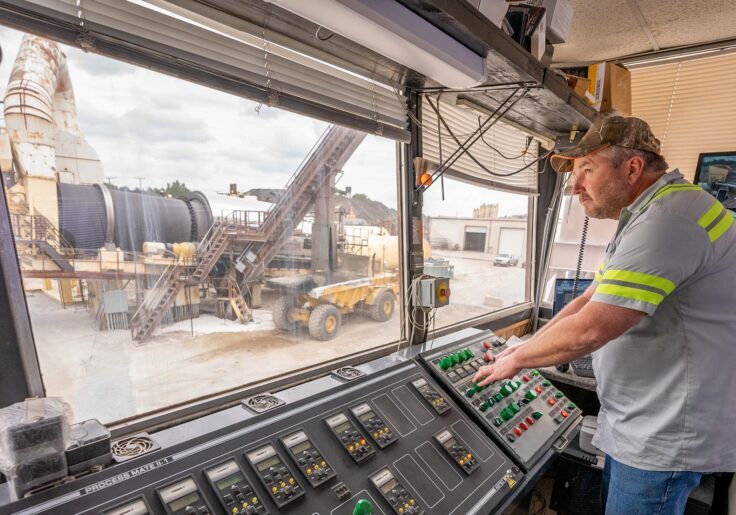 A male worker who is in a control room at an asphalt plant in Maryland owned and operated by Gray & Son a leading site and development contractor in Maryland.