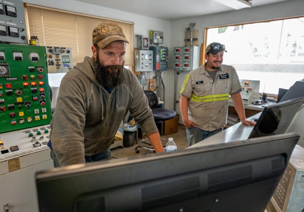 two men looking at computers in the control room at an asphalt storage site located in maryland, owned and operated by Gray & Son a leading site and development contractor in Maryland.